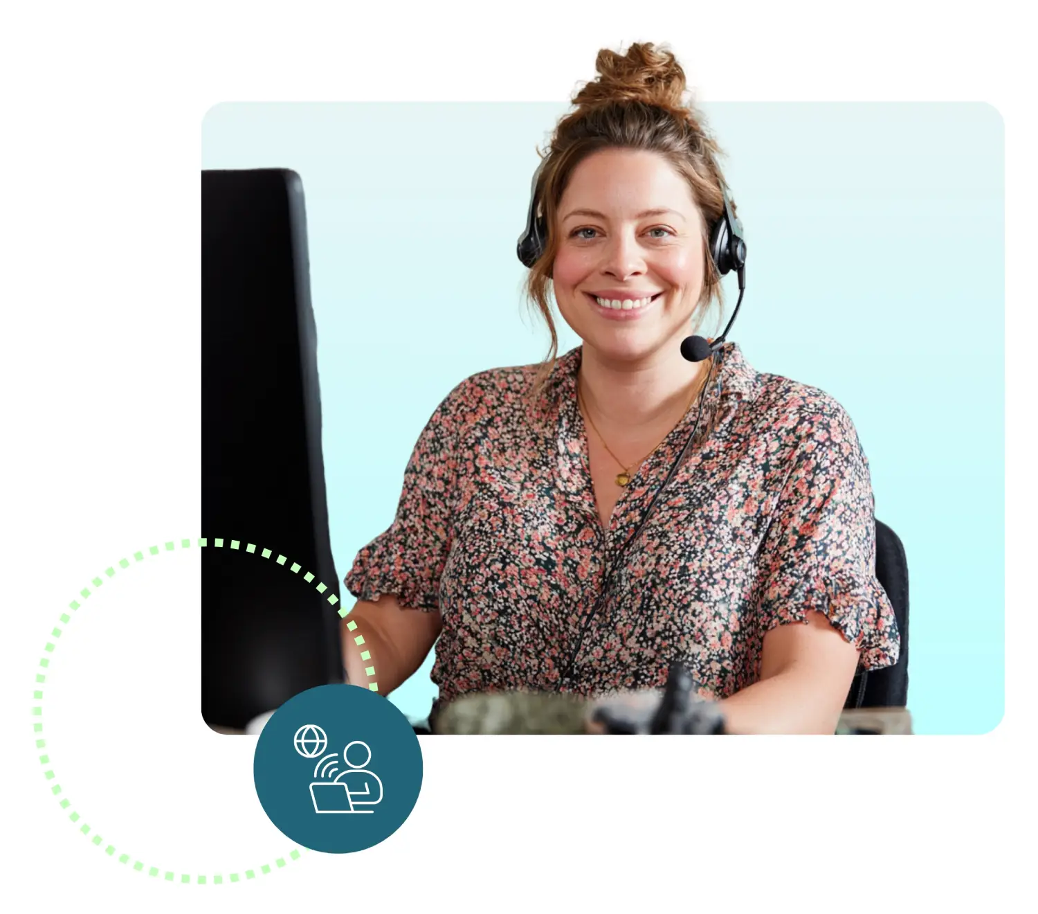 A woman wearing a headset, smiling at her computer